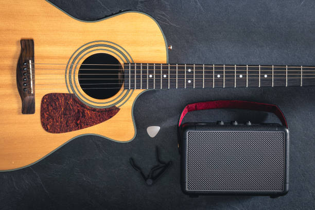 istock Acoustic guitar and speaker on a black background, top view. 2083878743