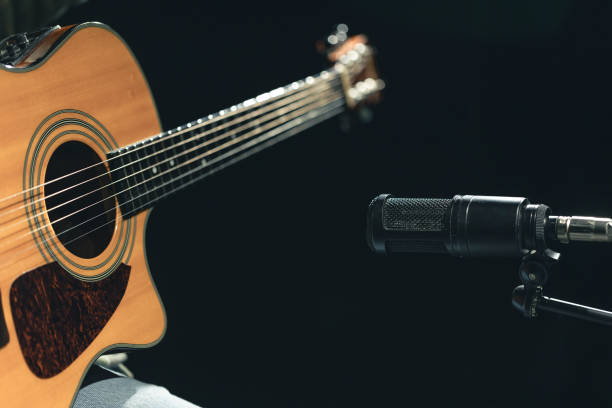 istock Acoustic guitar and microphone, recording in a music studio. 2083883165