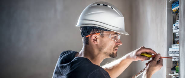 istock Male electrician working in switchboard with electrical connection cable. 2083915949