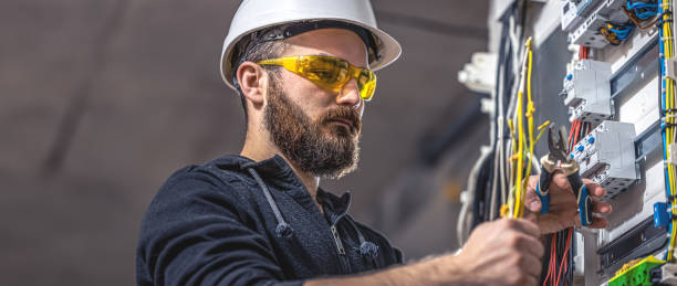 istock A male electrician works in a switchboard with an electrical connecting cable. 2083915964
