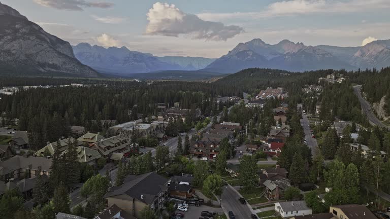 Banff AB Canada Aerial v5 flyover foothill town center and residential areas capturing local community surrounded by lush forested valleys and mountain ranges - Shot with Mavic 3 Pro Cine - July 2023
