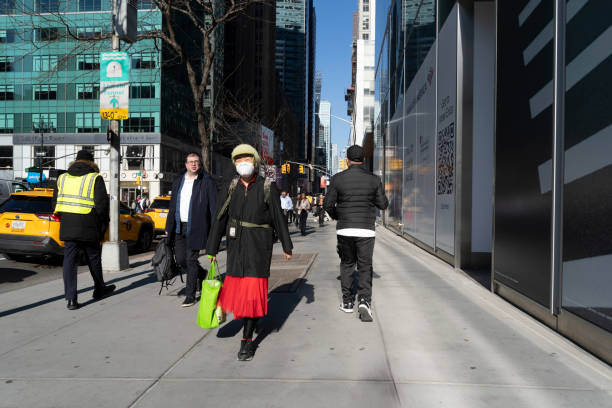Manhattan, New York, USA - March 2024. Street photography in Manhattan.  In the foreground are people walking to work.