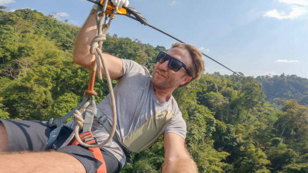 morning flight: zip-lining over laos' tropical rainforest - zip lining - fotografias e filmes do acervo