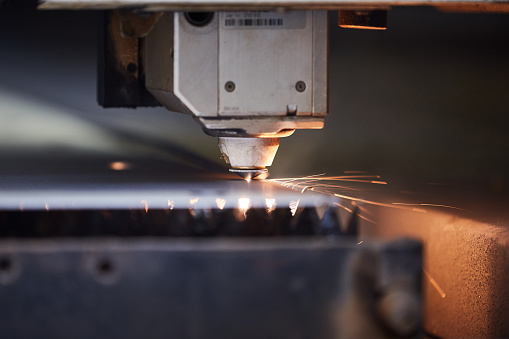 close-up of a laser cutter cutting through metal sheet