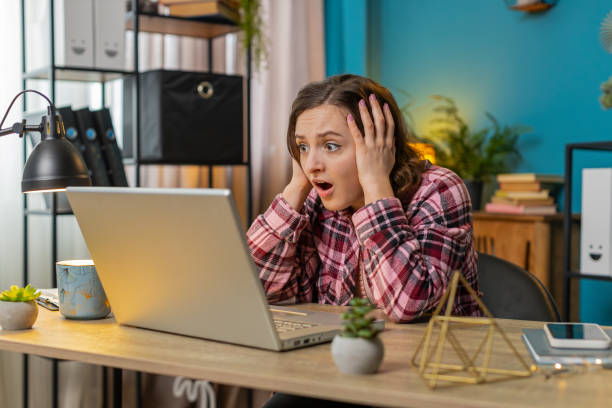 istock Displeased sad woman using working on laptop loss game fail computer virus at home office table 2084026771