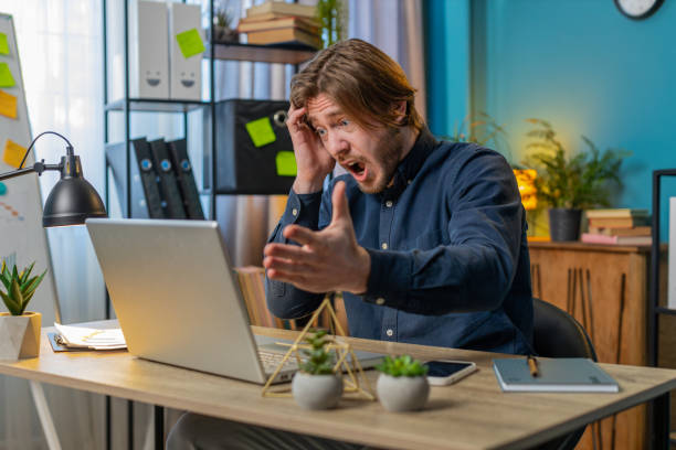 istock Displeased sad businessman using laptop loss game fail computer virus error bad news at home office 2084040457