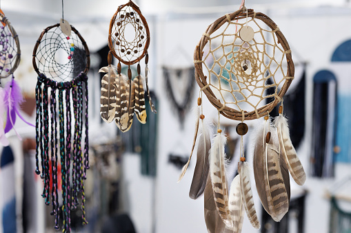 Various feather dream catchers made from the evil eye and souvenir magnets hanging on the walls and roof are sold in the market shop