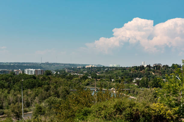 Scenic views along the Bow River pathway area for pedestrians, bicycles during summer spring on beautiful blue sky day.