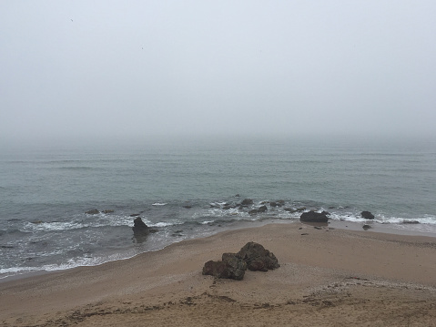 Foggy day beach background. Coastline background with fog. Seascape with fog