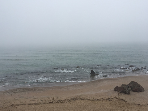 Foggy day beach background. Coastline background with fog. Seascape with fog