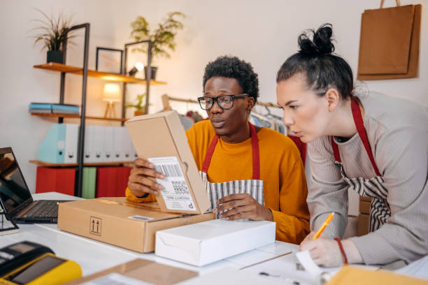 istock Young people working in packing and delivery service. Preparing package to fill in customer order 2084107831