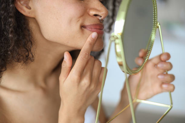 istock A womans hand touches her jaw while admiring her eyelashes in the mirror 2084147747