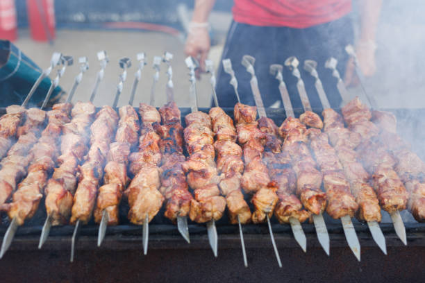 Succulent and delicious grilled meat skewers on the bbq rack with flames and sparks. Succulent and delicious grilled meat skewers on the bbq rack with flames and sparks bbq smoker stock pictures, royalty-free photos & images