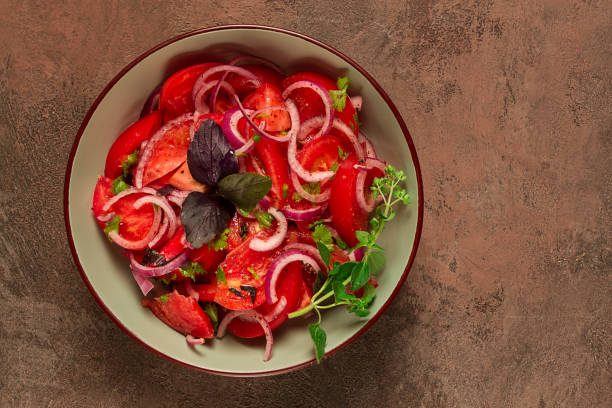 fresh tomato salad, with red onion, spices and herbs, top view, close-up, homemade,