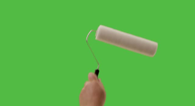 Hand Using Paint Roller To Cover Entire Green Screen from Left to Right.