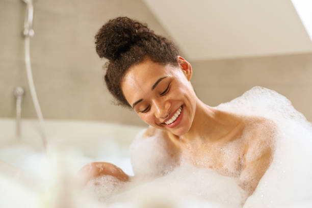 istock Smiling bride bathing in foamfilled bathtub at wedding event 2084168143