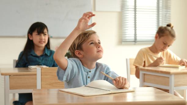 istock Boy raise hand for volunteering to answer while teacher walking pass. Pedagogy. 2084168671