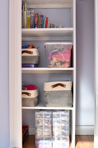 Closet cabinet storage shelving in wardrobe for children's playroom or bedroom for de-cluttering and neat toy and book storage