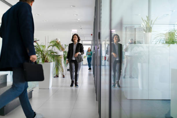 istock Colleagues greeting each other in the office hallway 2084232165