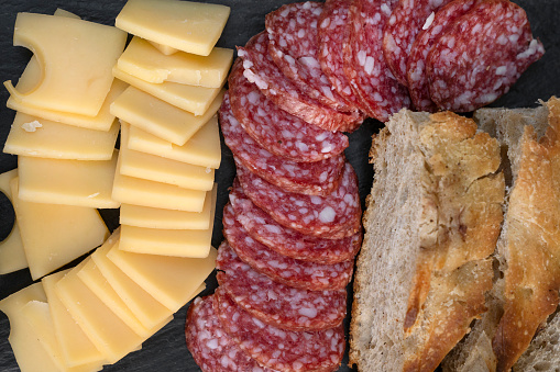 Antipasto. Top view of a dish with sliced salami, cheese and focaccia bread.