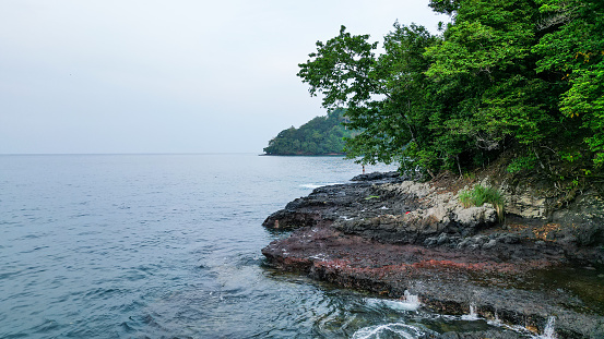 A green beach and ocean in Praia Grande, Sao Tome, South Africa