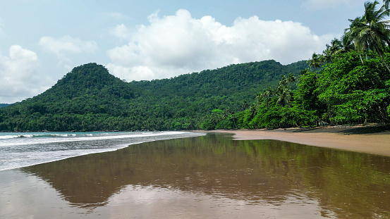 A green beach and ocean in Praia Grande, Sao Tome, South Africa,