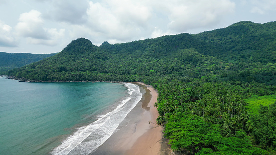 A green beach and ocean in Praia Grande, Sao Tome, South Africa