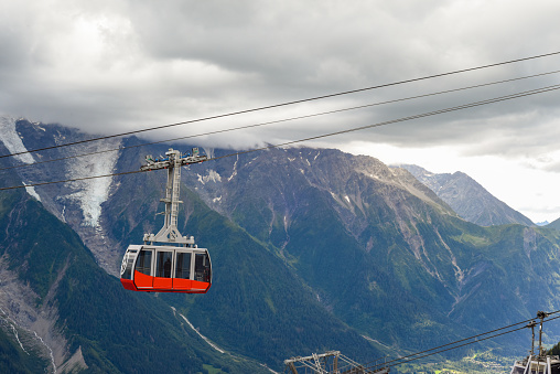 A person rides a cable car over the mountains of a ski resort