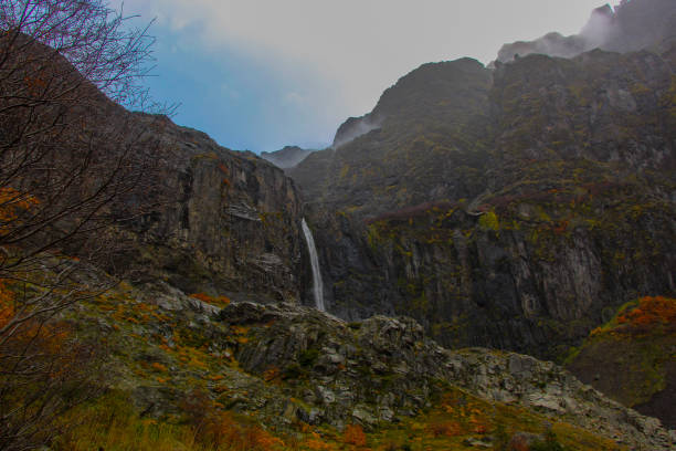 Waterfall on a rocky mountain on a cloudy autumn day.