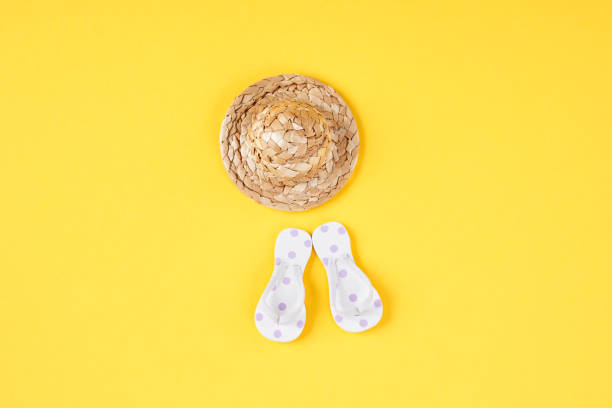 Green flip flops with polka dots and pink stripes on the white background