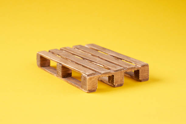 istock A wooden transport pallet on a yellow background. 2084352142