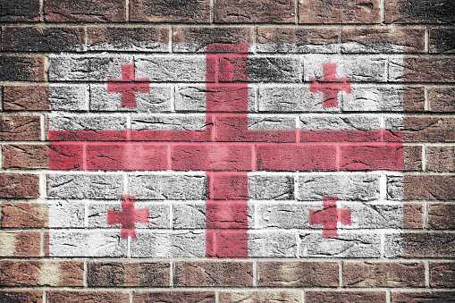 A Georgia flag painted on brick wall background