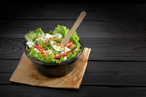 Salad with red fish or tuna and lettucce in a plastic bowl. Healthy fast food