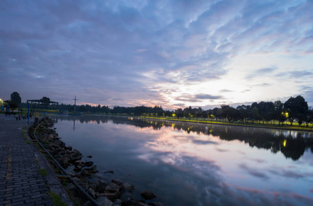 Landscape of a lake in park at dawn, with reflection of blue sky