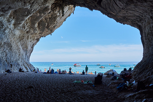 Dorgali, Italy - October 6, 2022: tourists visiting natural caves in Cala Luna, a famous tourist destination on Eastern Sardinia. Dorgali municipality. Province of Nuoro. Sardinia. Italy.