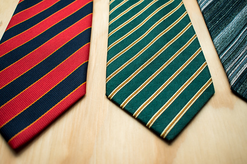 Some different ties on a wooden table