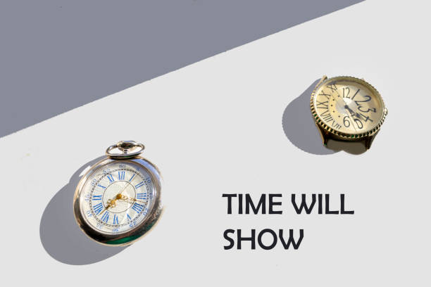 Time will tell. The clock, lying on a white-gray background, shows that time always passes, although it is not always visible.