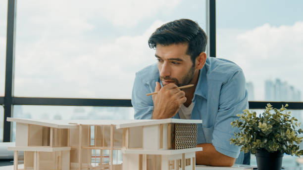 istock Closeup of skilled engineer check, inspect, look at house model. Tracery 2084405925