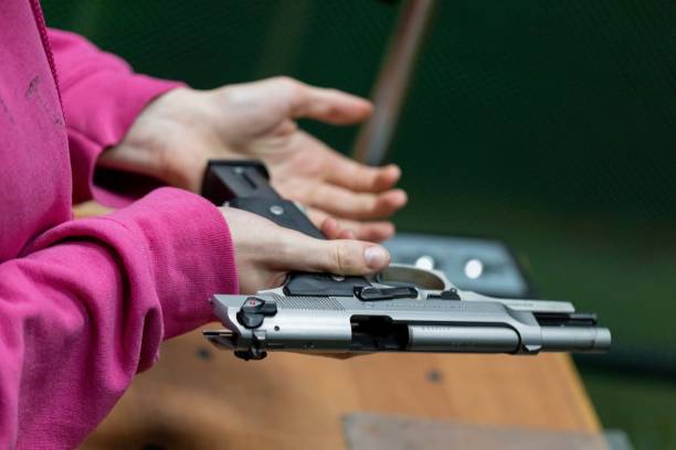 istock Loading a magazine to reload a gun in your hands at the shooting range 2084406963