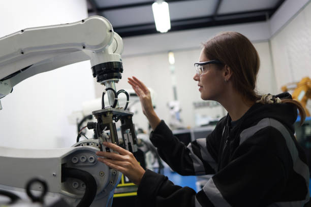istock A female mechatronics engineer is working with a robotic arm prototype to examine new programming in the quality room at a manufacturing  welding  factory 2084424926