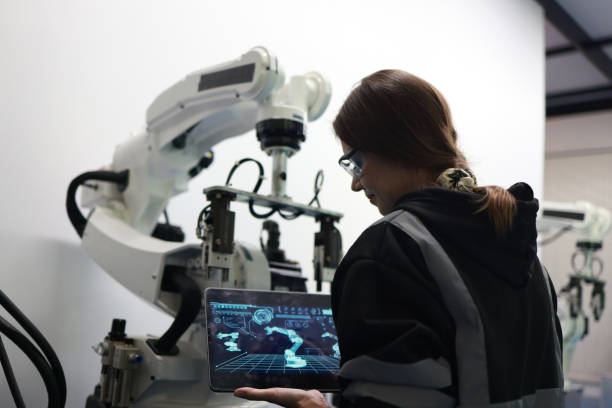 istock A female mechatronics engineer is working with a robotic arm prototype to examine new programming in the quality room at a manufacturing  welding  factory 2084424942