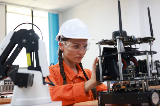 istock A female industrial engineer is inspecting an engineered automation machine that has robotic arms and a cylinder in a factory setting. 2084427583