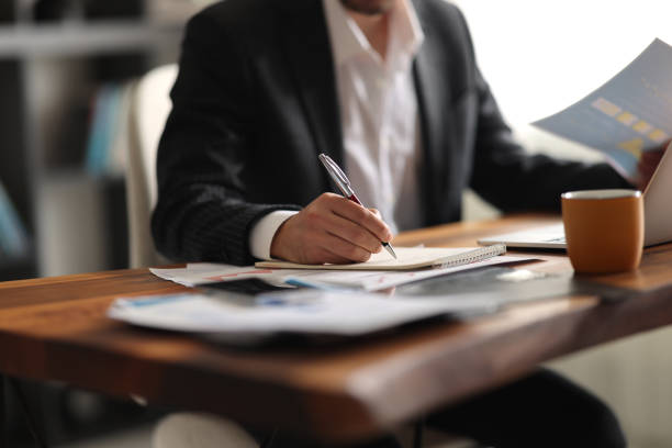 Business accounting concept, Business man using calculator with computer laptop, budget and loan paper in office.