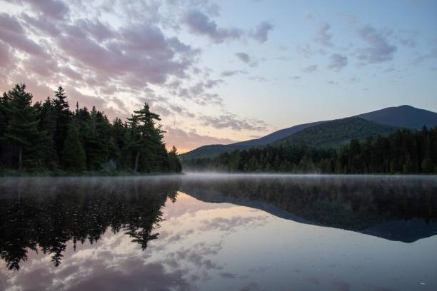 istock A tranquil sunrise reflected in a calm lake 2084483872