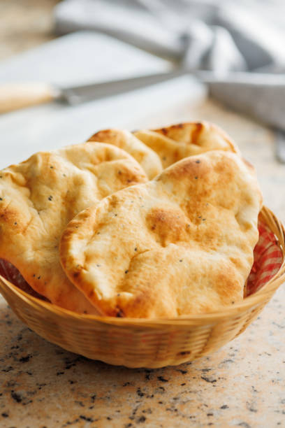 istock Freshly Baked Naan Bread in basket on kitchen table. 2084524104