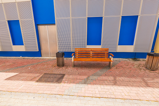 Beautiful view of an empty wooden bench next to a  building on the sidewalk in the center of Willemstad city. Curacao.
