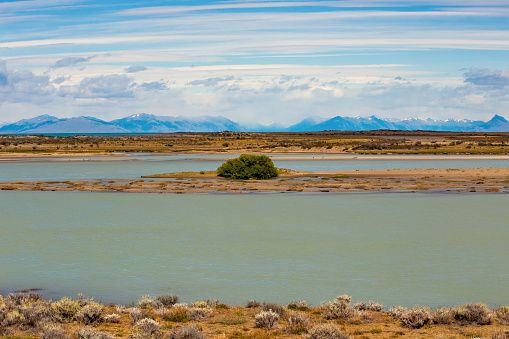 An aerial view of an empty straight road on a causeway under blue sky in a Utah winter.