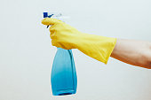 Hand in Yellow Glove Holding Spray Bottle