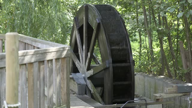 old wooden watermill turn in water power rural static tripod shot