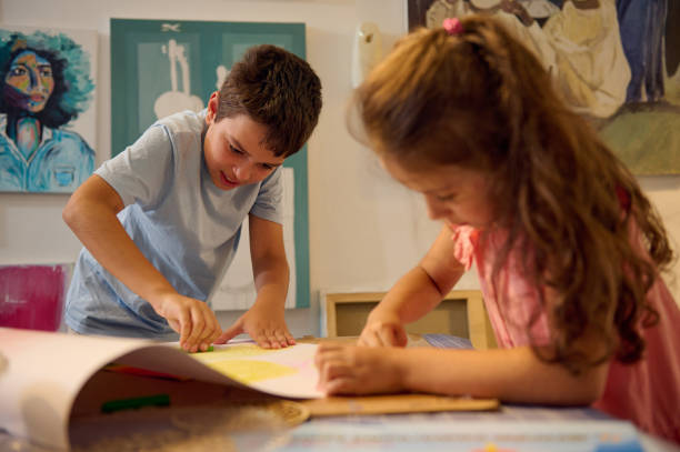 istock Two children, elementary age schoolkids drawing picture during art class. 2084615432
